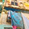 Bunte Wäsche hängt vom Balkon in Havannas Altstadt auf Kuba - Gruppenreisen für Alleinreisende & Erlebnisreisen | QUERIDO MUNDO